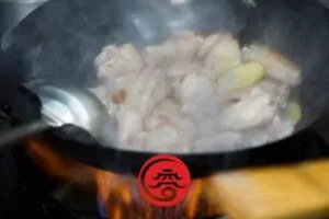 Hähnchenflügel ins Wok geben; braten, bis die Hähnchenflügel braun werden - Drei Tassen Huhn Rezept 三杯雞食谱 
