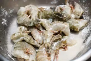 Garnelen marinieren Garnelen mit Ei benetzen. Ein Esslöffeln Kartoffelstärker dazu geben. Mischen